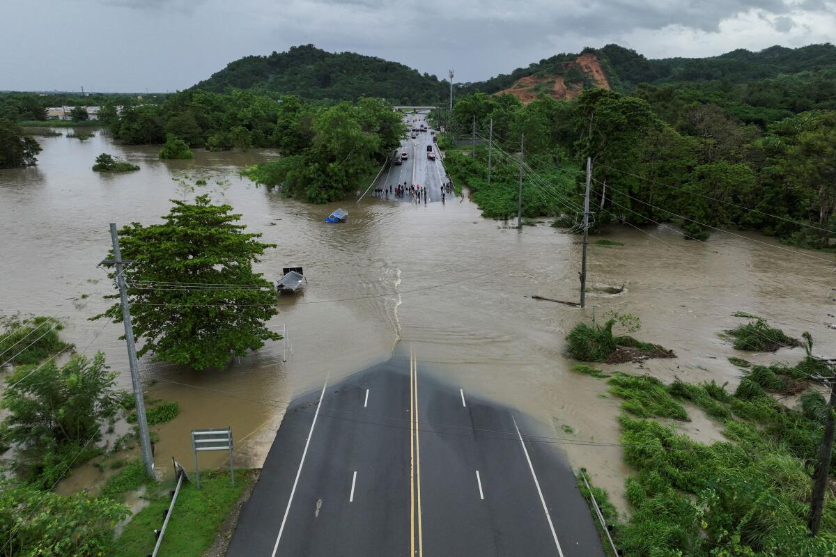A drone view shows a bridge submerged by the flooded La Plata River in the aftermath of Tropical Storm Ernesto in Toa Baja, Puerto Rico.