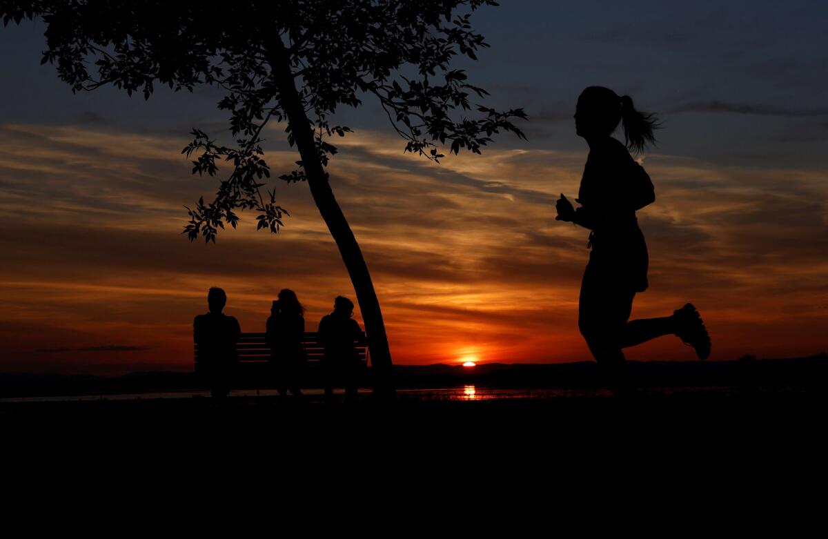 People enjoy sunset at lake Zicksee during a heatwave in Austria.