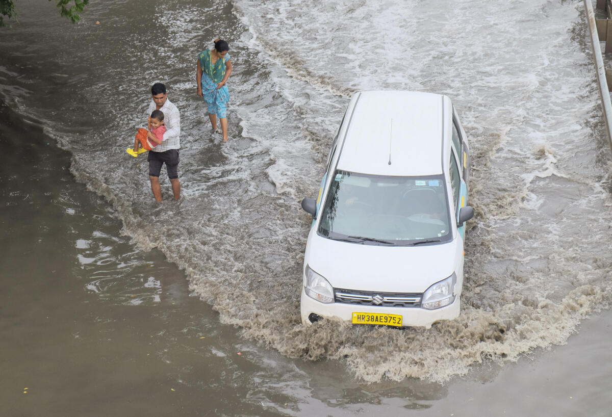 A vehicle pass through waterlogged Delhi-Gurugram Expressway service road after heavy rains, in Gurugram.