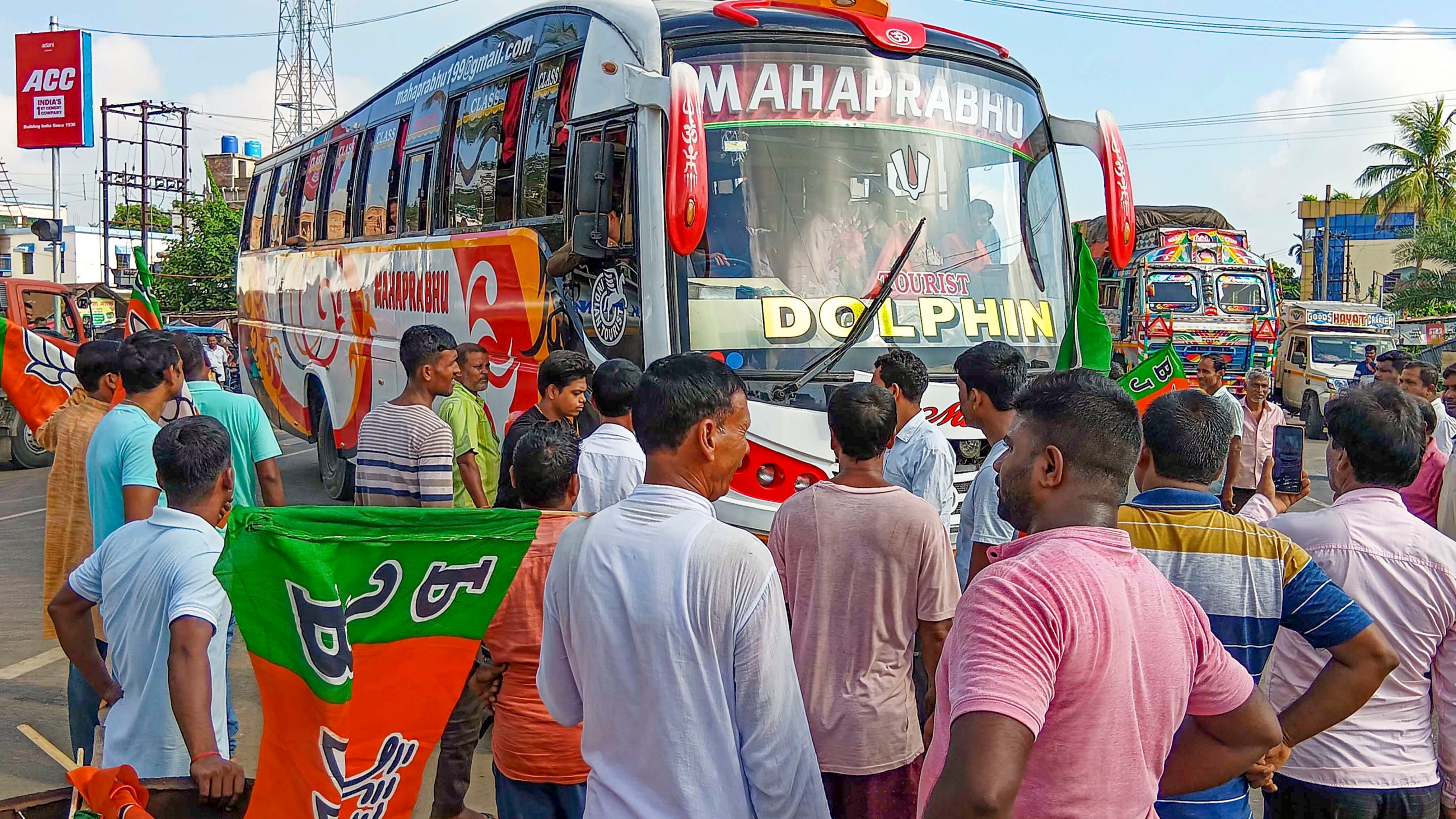 BJP workers stop a bus on National Highway 12 during the party's 12-hour general strike in Bengal.