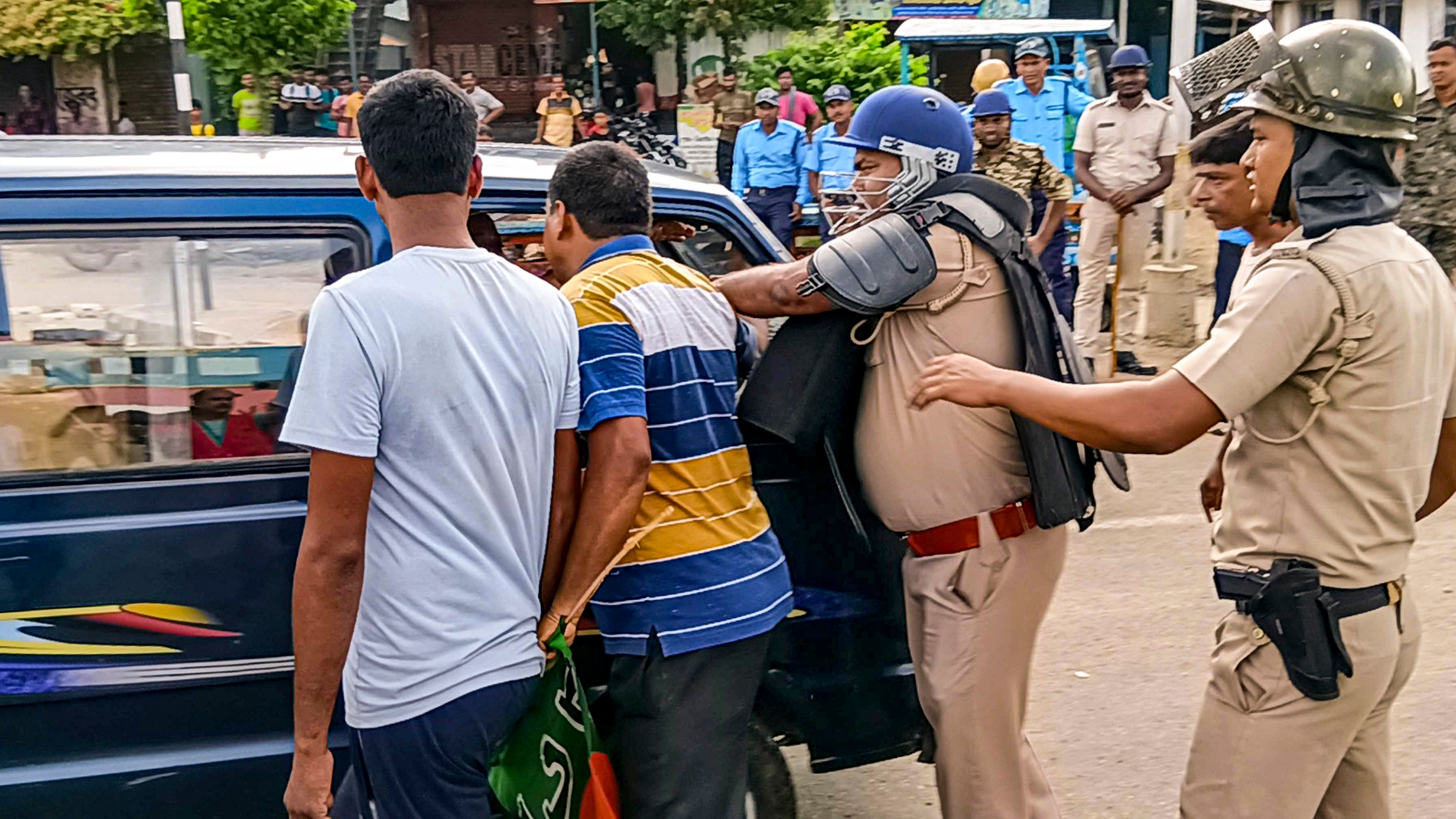 Police personnel try to stop BJP workers from blocking a vehicle during the party's 12-hour general strike in Bengal.