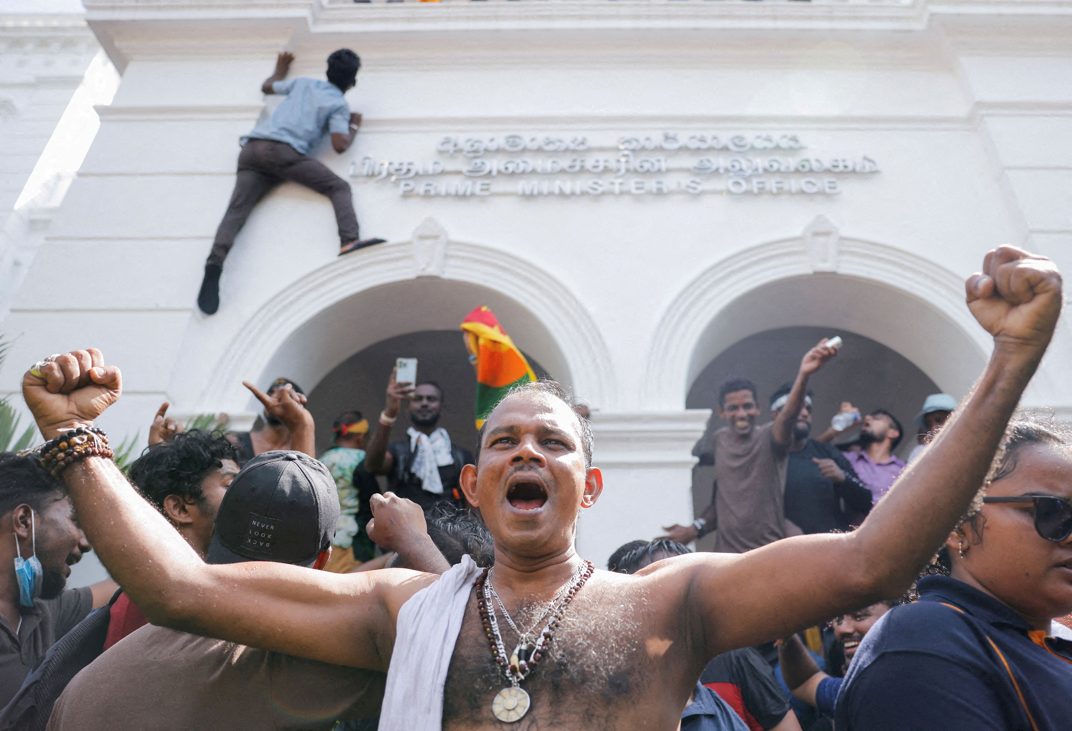 FILE PHOTO: Demonstrators celebrate after they entered into Sri Lankan Prime Minister Ranil Wickremasinghe's office during a protest demanding for his resignation, after President Gotabaya Rajapaksa fled, amid the country's economic crisis, in Colombo, Sri Lanka, July 13, 2022. 