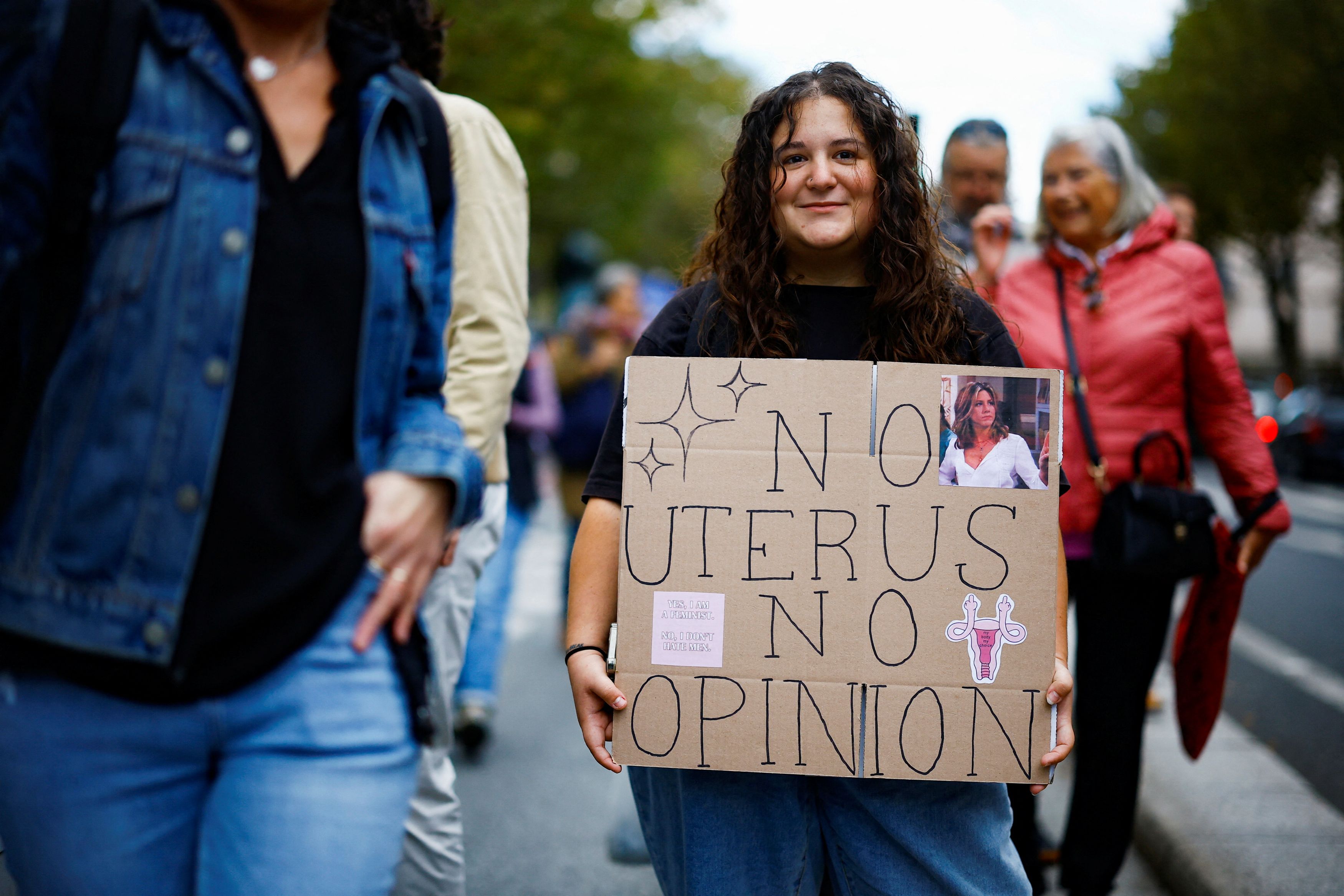 A woman holds a placard reading "No uterus no opinion" as people gather to mark International Safe Abortion Day in Paris, France, September 28, 2024. 