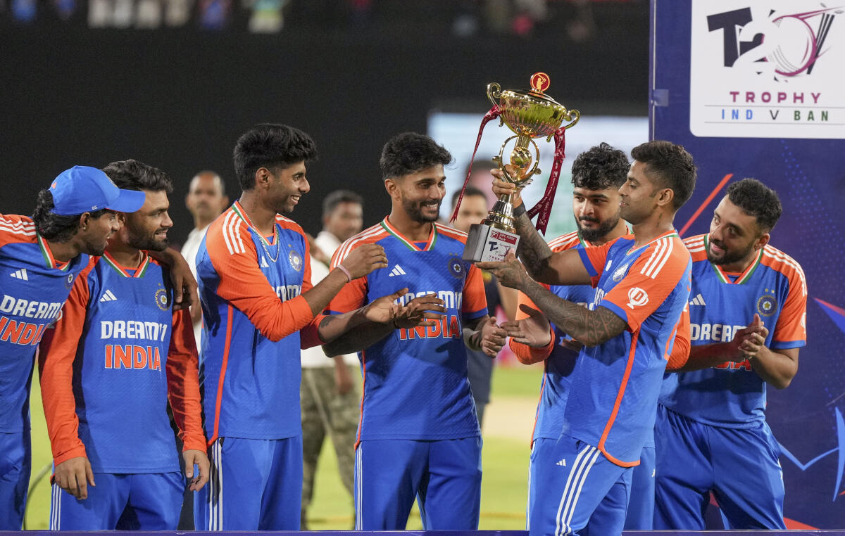 India's captain Suryakumar Yadav hands over the championship trophy to teammates during the presentation ceremony after winning the third and final T20 International cricket match between India and Bangladesh.