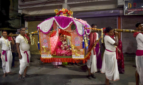 Devotees carry a child on a ‘palki’ during ‘Kumari Puja’, in Kolkata.