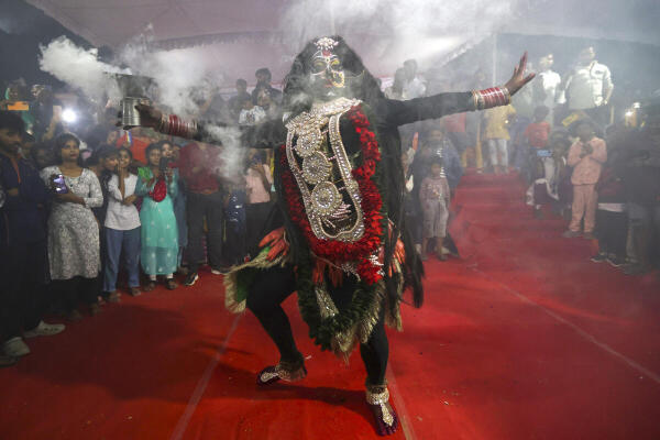 An artist dressed as Goddess Kali performs during ‘Kalindi Mahotsav’, in Prayagraj.