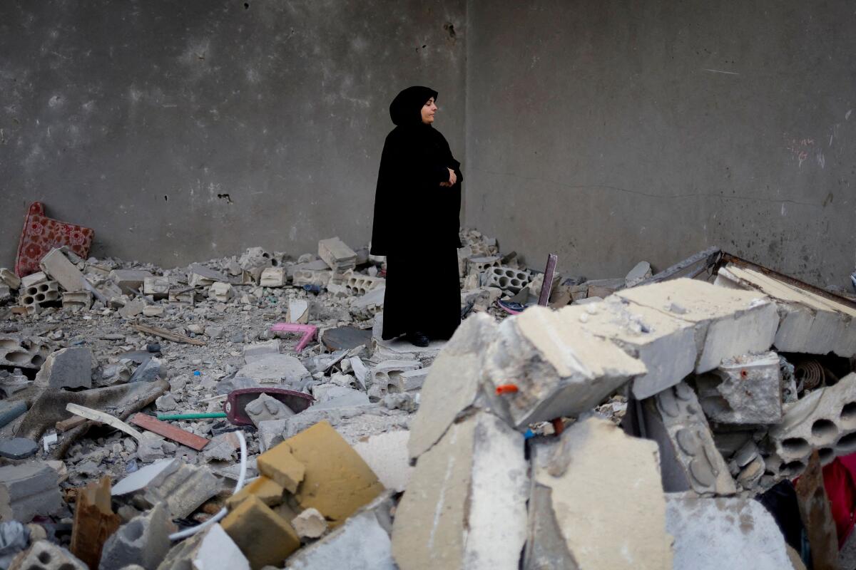 A woman stands among the rubble of her house after a ceasefire between Israel and Hezbollah took effect, in Tyre, Lebanon.
