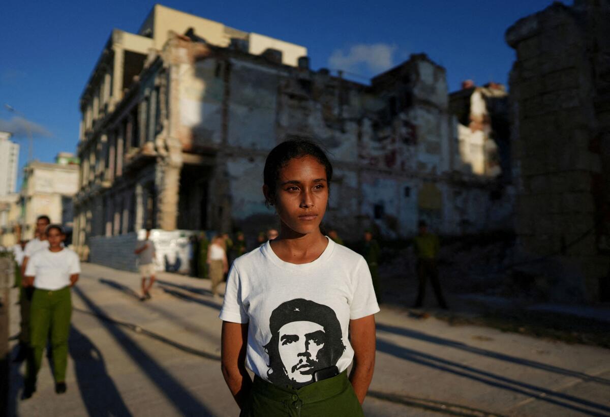 A Cuban recruit wearing a t-shirt with an image of late revolutionary hero Ernesto "Che" Guevara looks on during a ceremony marking the 153rd anniversary of the execution of eight medicine students by the Spanish colonial government, Havana, Cuba.