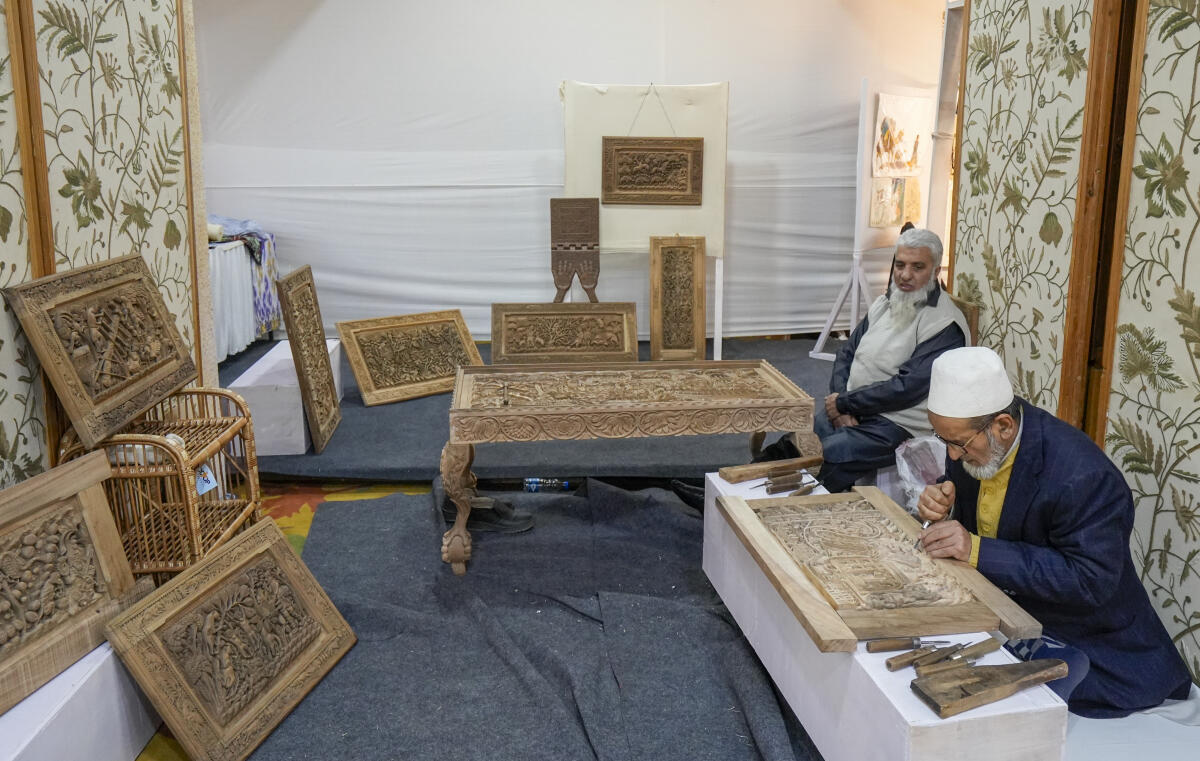An artisan gives demonstration of wood carving work during the World Craft Council's 60th Jubilee celebration at SKICC, in Srinagar.