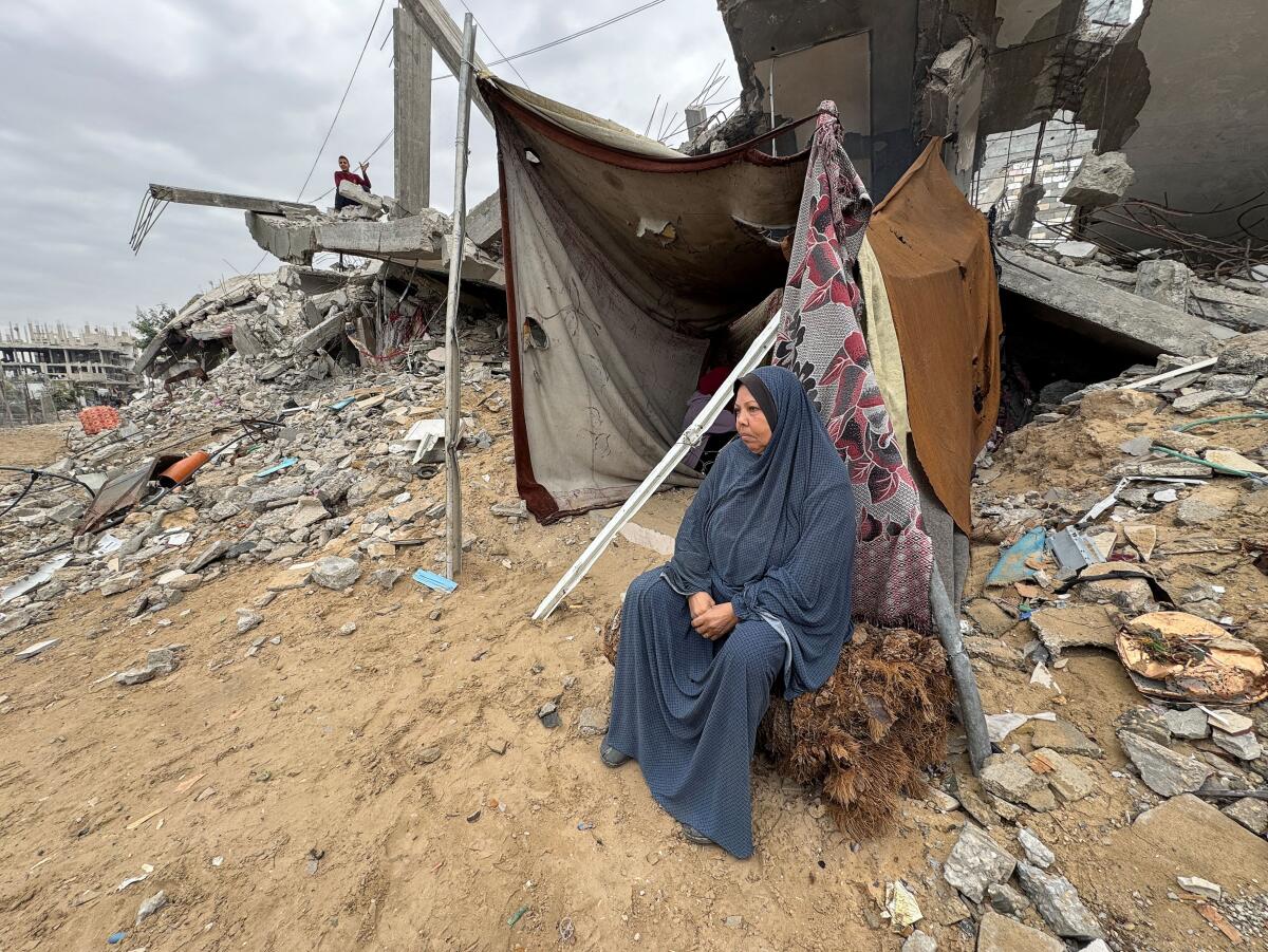 A Palestinian woman sits near the ruins of a house destroyed during the Israeli military offensive, amid the Israel-Hamas conflict, in Khan Younis in the southern Gaza Strip.