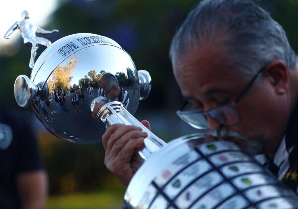 Botafogo fan kisses a replica of the Copa Libertadores trophy ahead of the final.