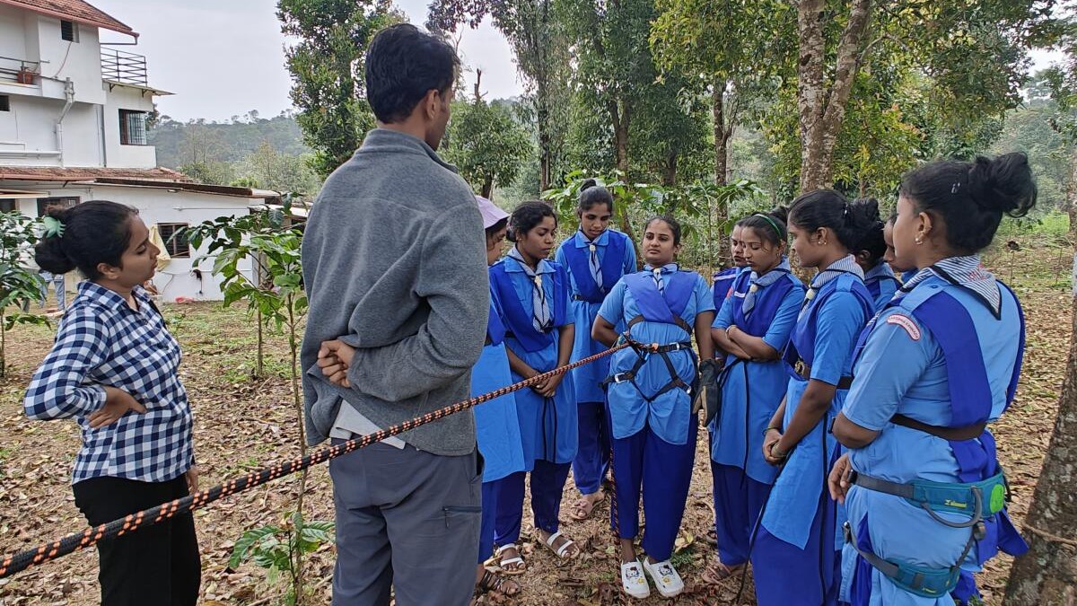 NCC cadets from Sharada Vidyalaya rappelling across a stream near Bowline Adventure camp in Mudigere.