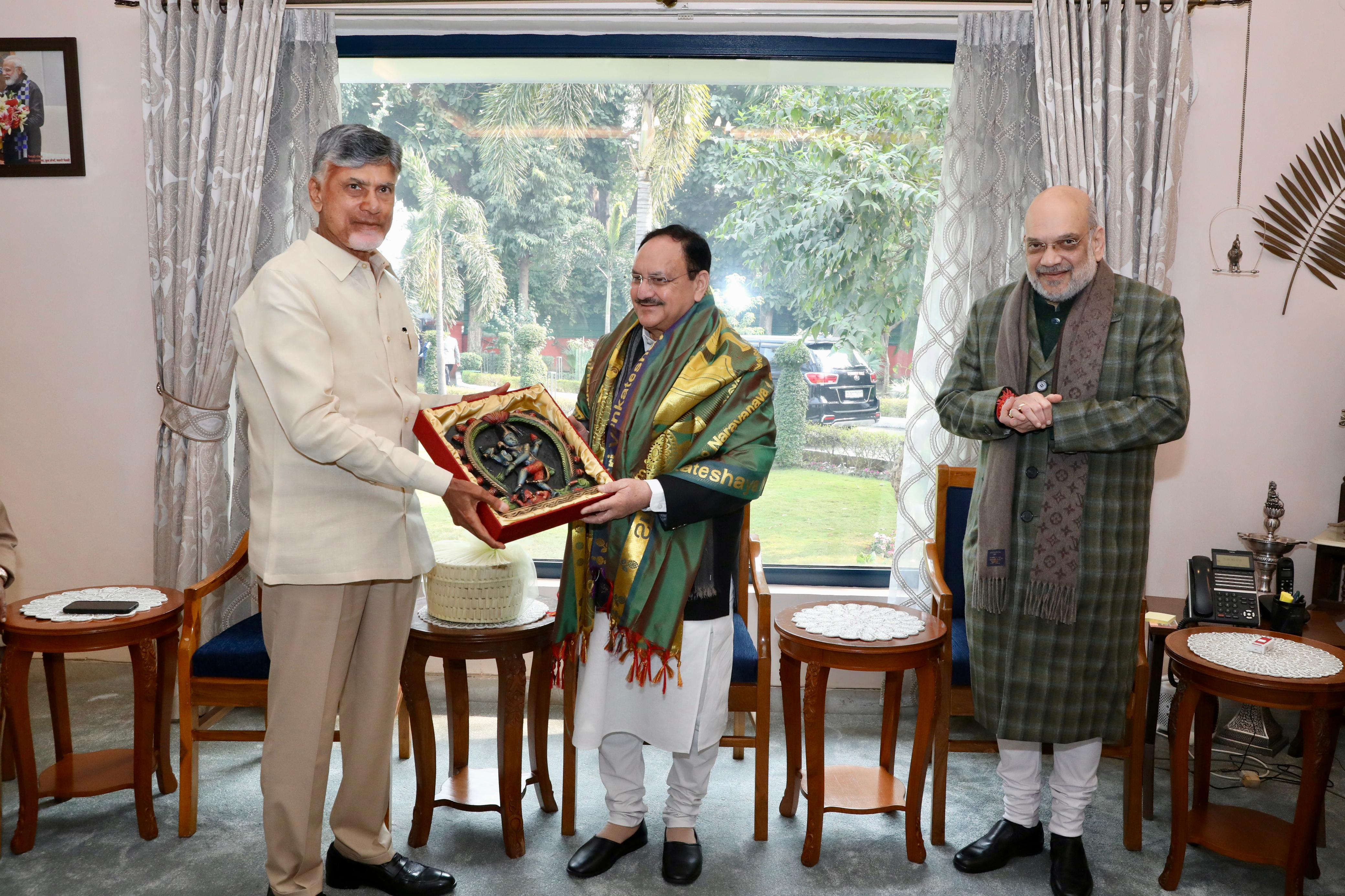 Chandrababu Naidu presents a memento to J P Nadda as Amit Shah looks on. 