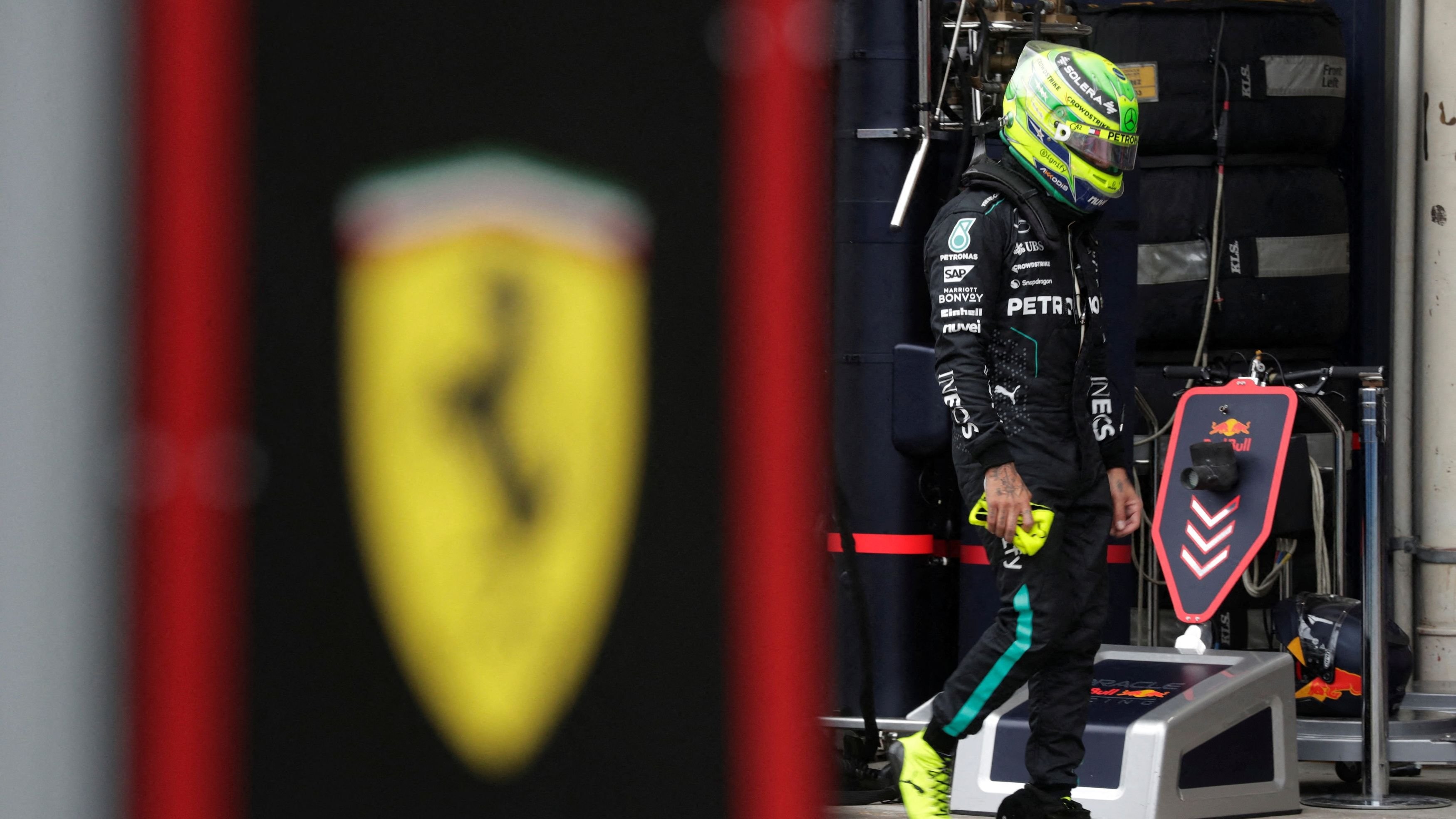 Lewis Hamilton  is seen pictured next to a Ferrari logo 