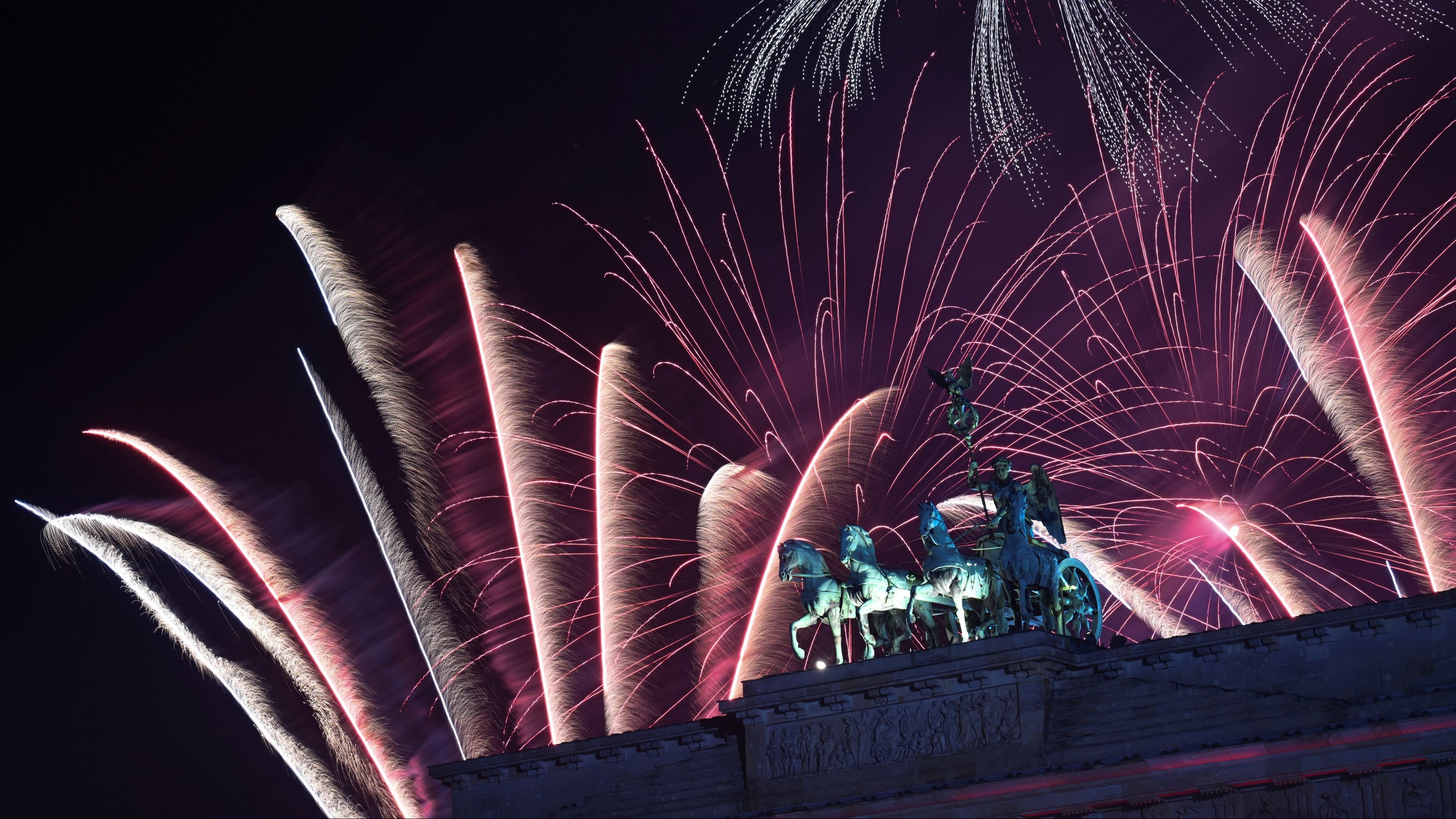Fireworks illuminate the Quadriga sculpture atop the Brandenburg Gate during New Year's celebrations in Berlin, Germany.