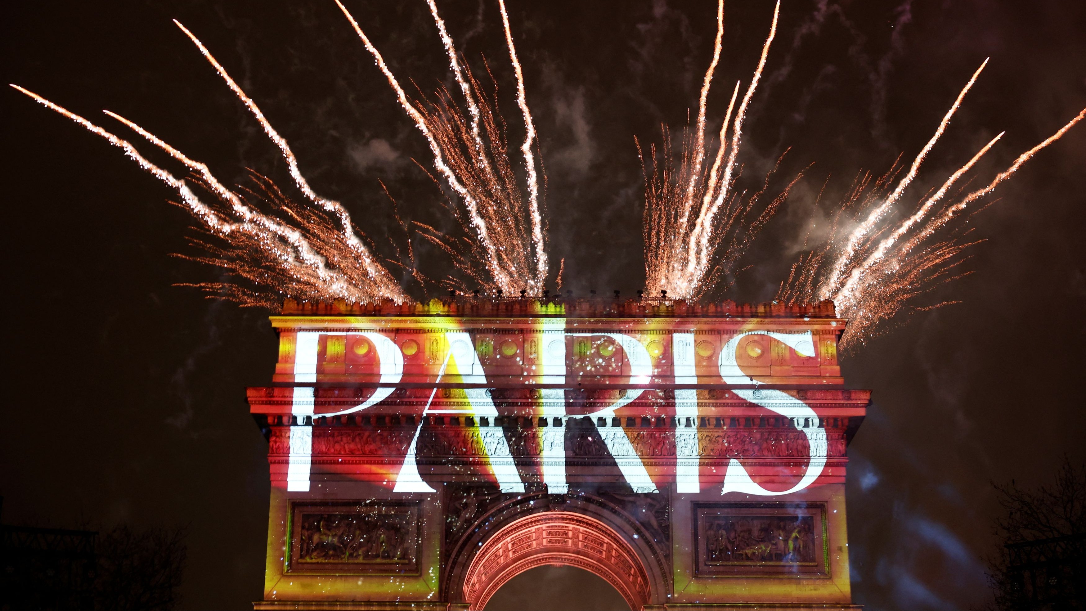 Fireworks explode as the Arc de Triomphe is illuminated during the New Year's celebrations on the Champs Elysees avenue in Paris, France.