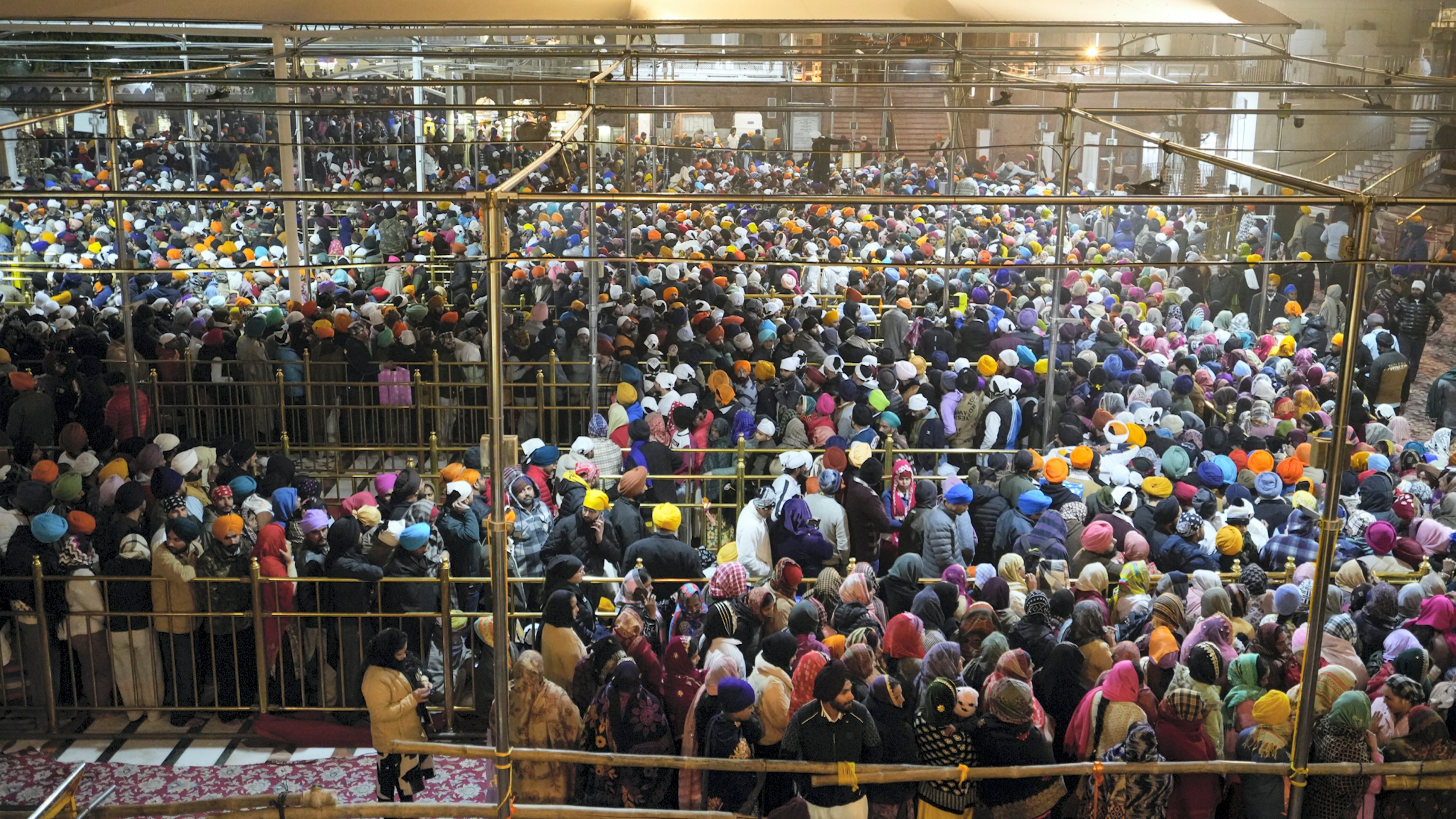 Hundreds of devotees stand in line to pay obeisance at the Golden Temple on the first day of the year 2025, in Amritsar.