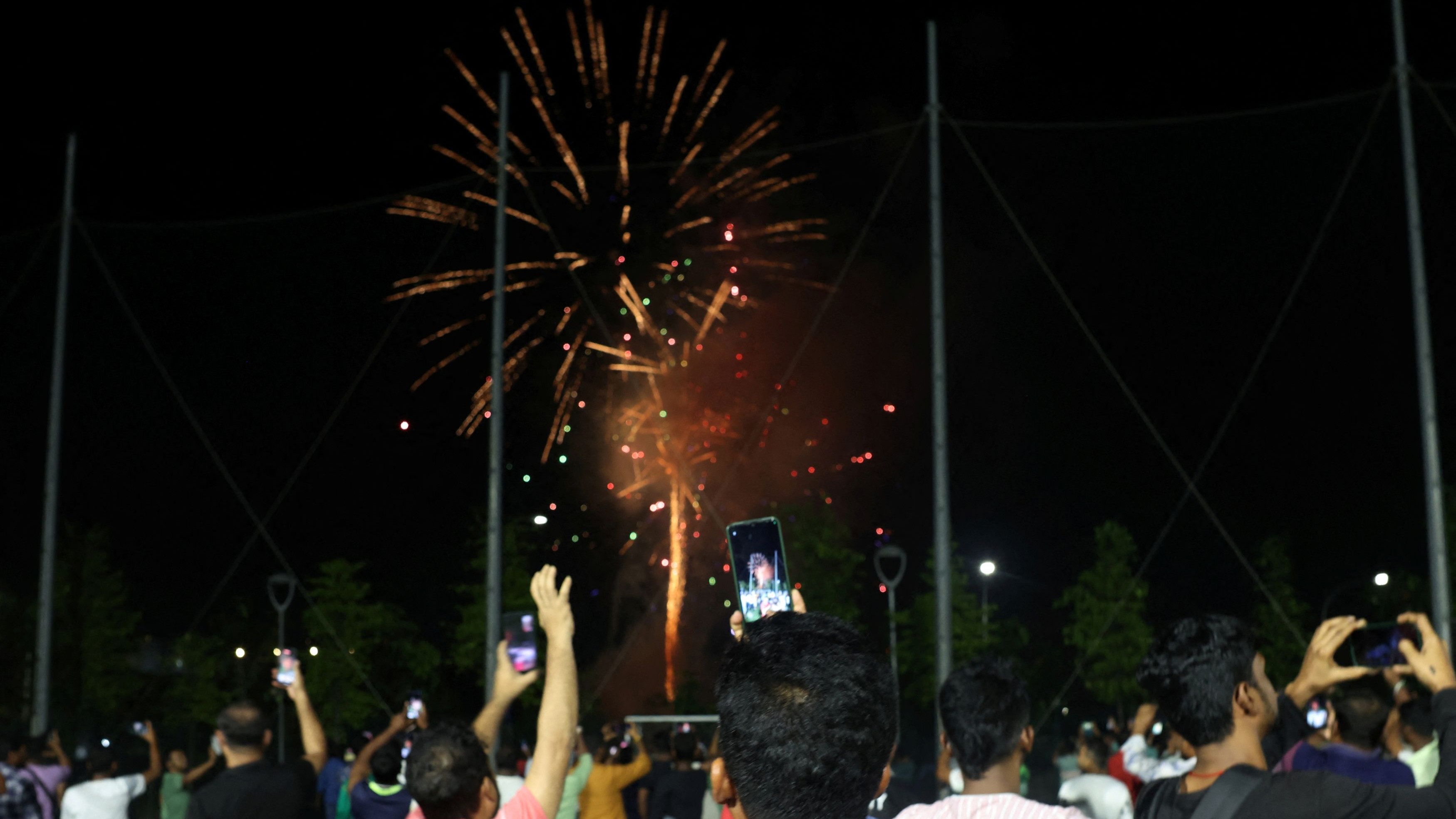 People take photos of fireworks during New Year’s Eve celebrations in Singapore.