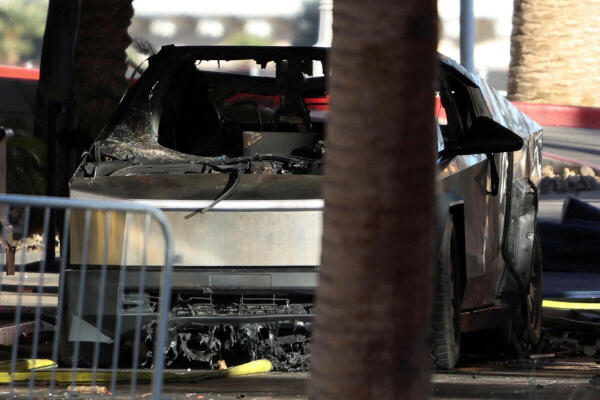 Firefighters work at the Tesla Cybertruck which burned at the entrance of Trump Tower in Las Vegas