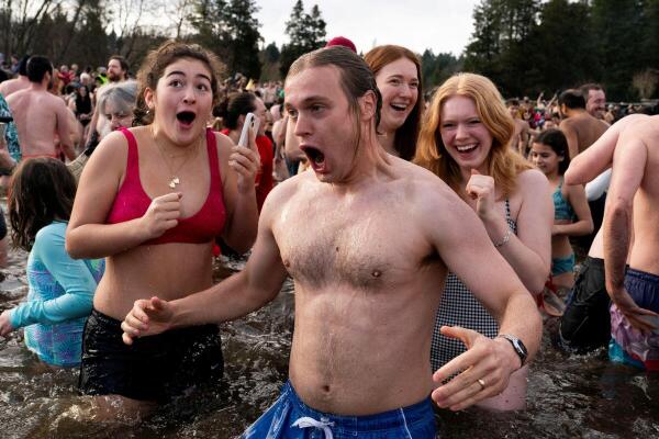 Participants enter Lake Washington during the annual Polar Bear Plunge at Matthews Beach Park in Seattle, Washington, US January 1, 2025.