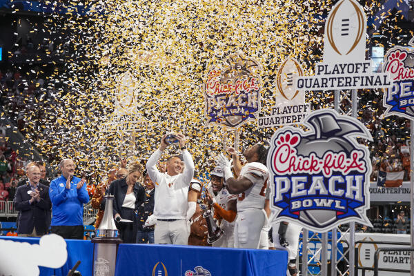 Texas Longhorns head coach Steve Sarkisian lifts the trophy after defeating the Arizona State Sun Devils at Mercedes-Benz Stadium.