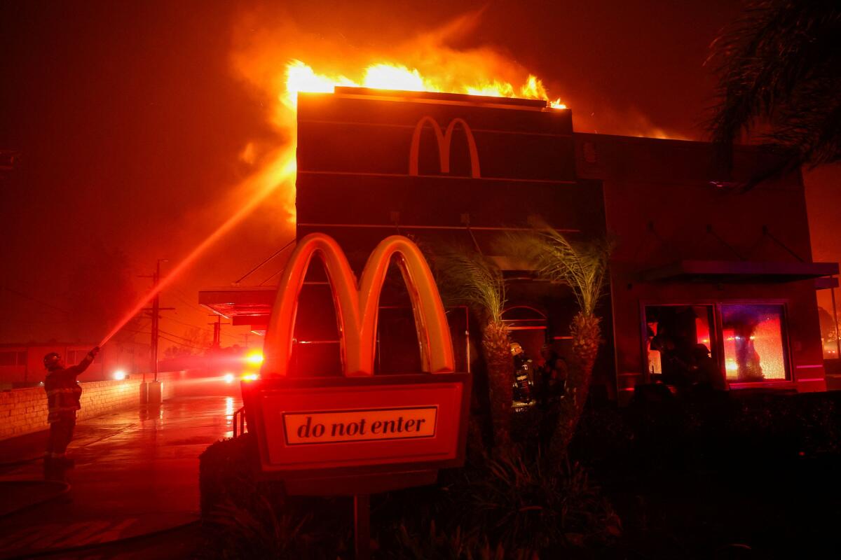 Firefighters work to extinguish flames as the Eaton Fire burns in Pasadena, California, U.S. January 7, 2025.