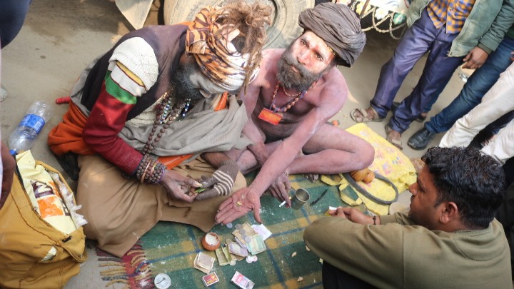 A devotee consults two sadhus at the MahaKumbh 2025 at Prayagraj, Uttar Pradesh.
