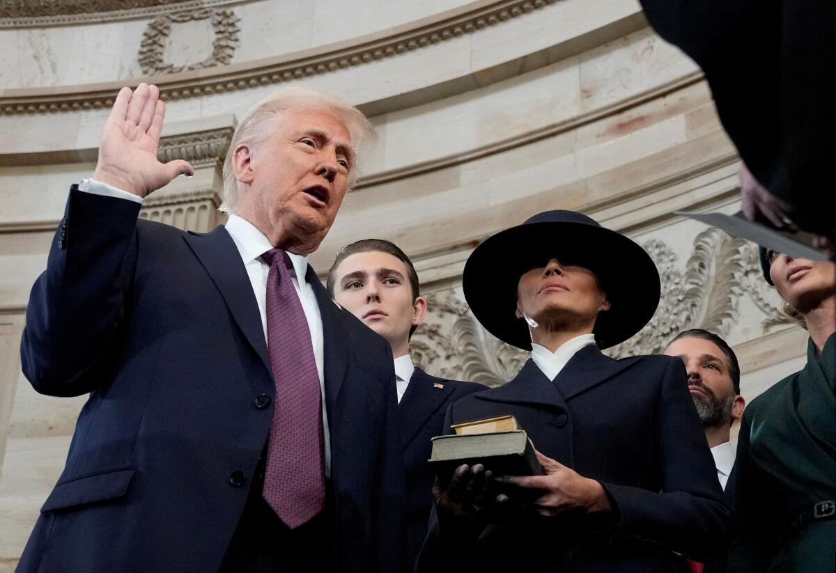 Donald Trump is sworn in as the 47th president of the United States by Chief Justice John Roberts as Melania Trump holds the Bible during the 60th Presidential Inauguration in the Rotunda of the U.S. Capitol in Washington, Monday, Jan. 20, 2025.