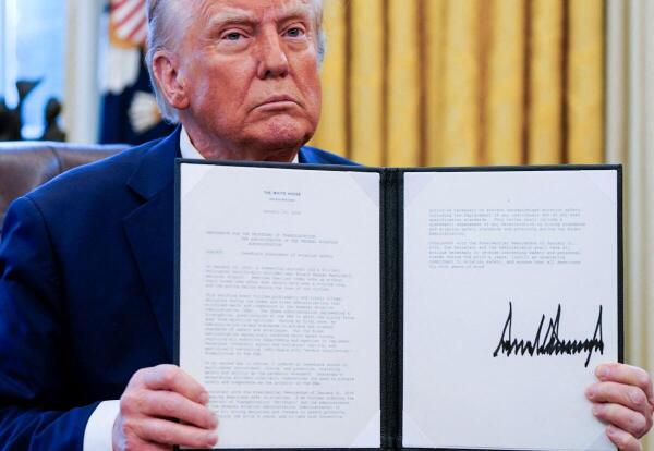 U.S. President Donald Trump holds up an executive order entitled "Immediate Assessment of Aviation Safety," following Wednesday's deadly midair collision between a U.S. Army Black Hawk helicopter and American Eagle flight 5342 near Ronald Reagan Washington National Airport, as he signs executive orders in the Oval Office at the White House in Washington.