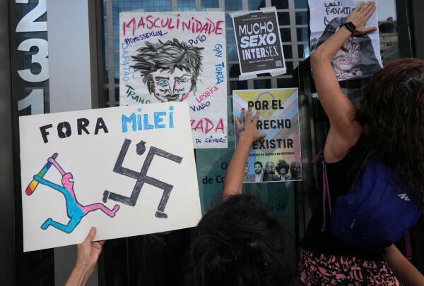 Activists in support of the LGBT+ community hang posters against Argentina's President Javier Milei at the Argentina's consulate in Sao Paulo, Brazil
