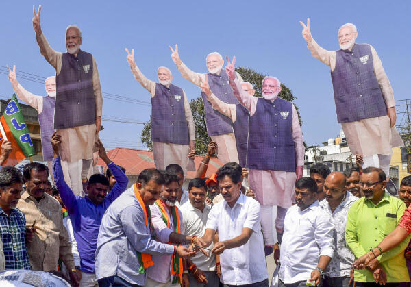 BJP leaders and workers with cut-outs of PM Narendra Modi celebrate the party's victory in Delhi Assembly polls, in Chikkamagaluru.