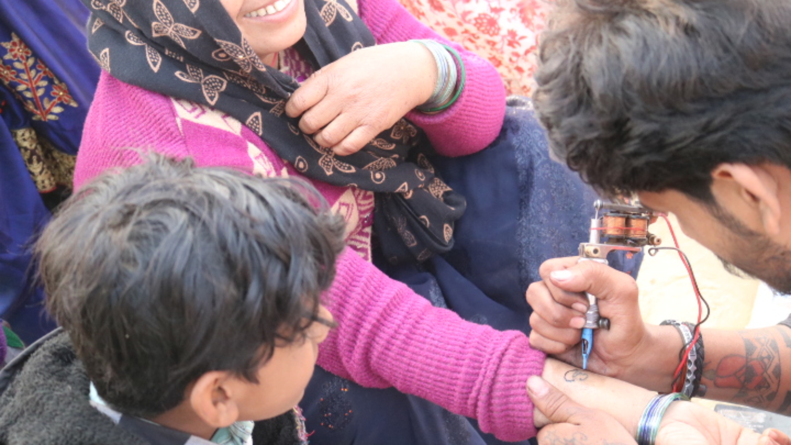 A devotee gets a religious insignia tattooed on her forearm, at the Maha Kumbh 2025, at Prayagraj, Uttar Pradesh, January 13.