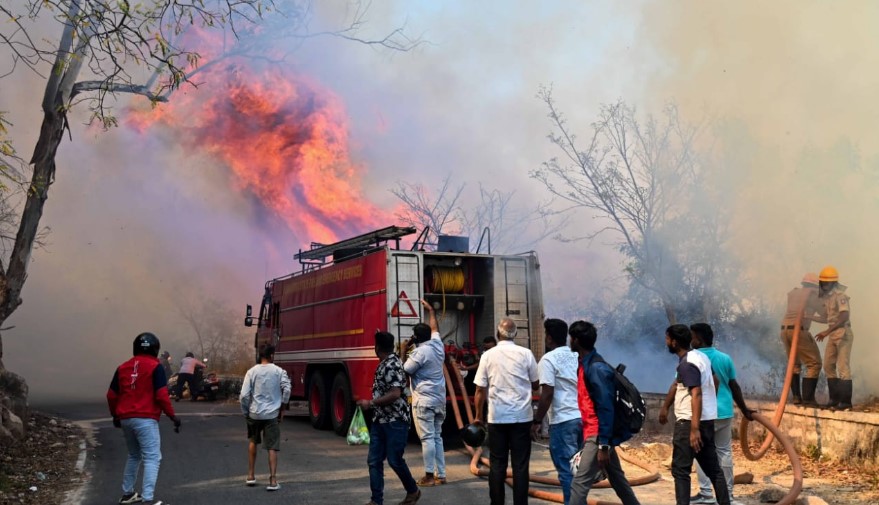 Karnataka State File and Emergency Service personnel dousing the fire at Chamundi Hills on February 21, 2025.