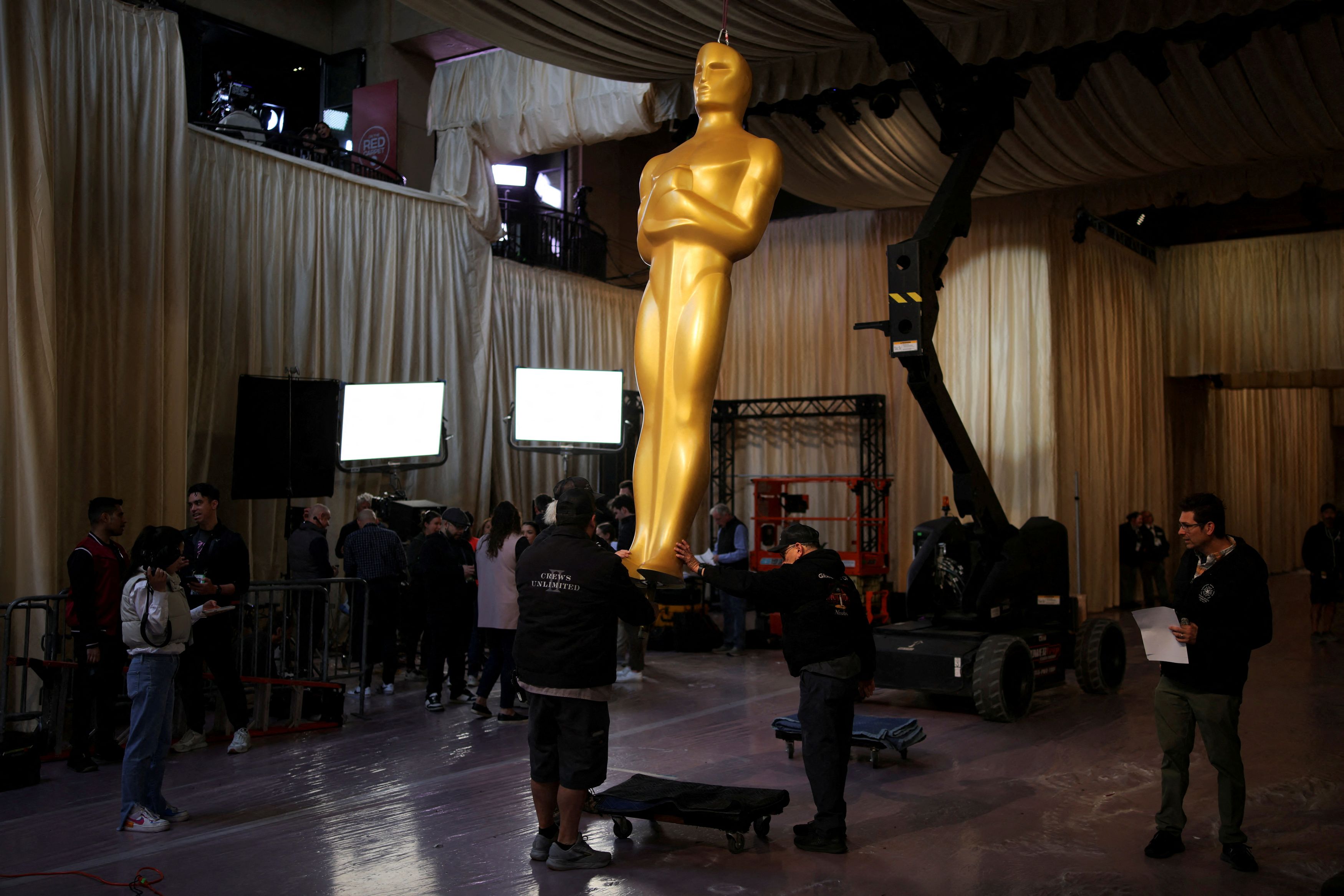Workers assemble an Oscar statue at the arrivals area for the 97th Academy Awards, as preparation continues in Los Angeles, California.