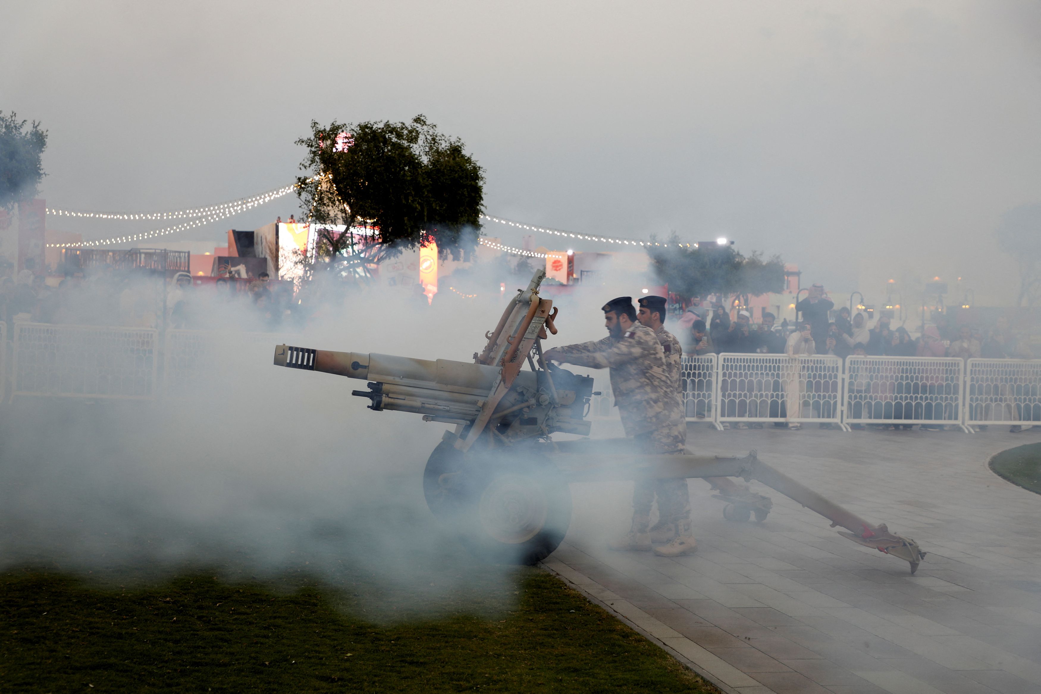 Qatari policemen fire a cannon to announce the time for the breaking of the fast, during the Muslim holy month of Ramadan, in Doha.