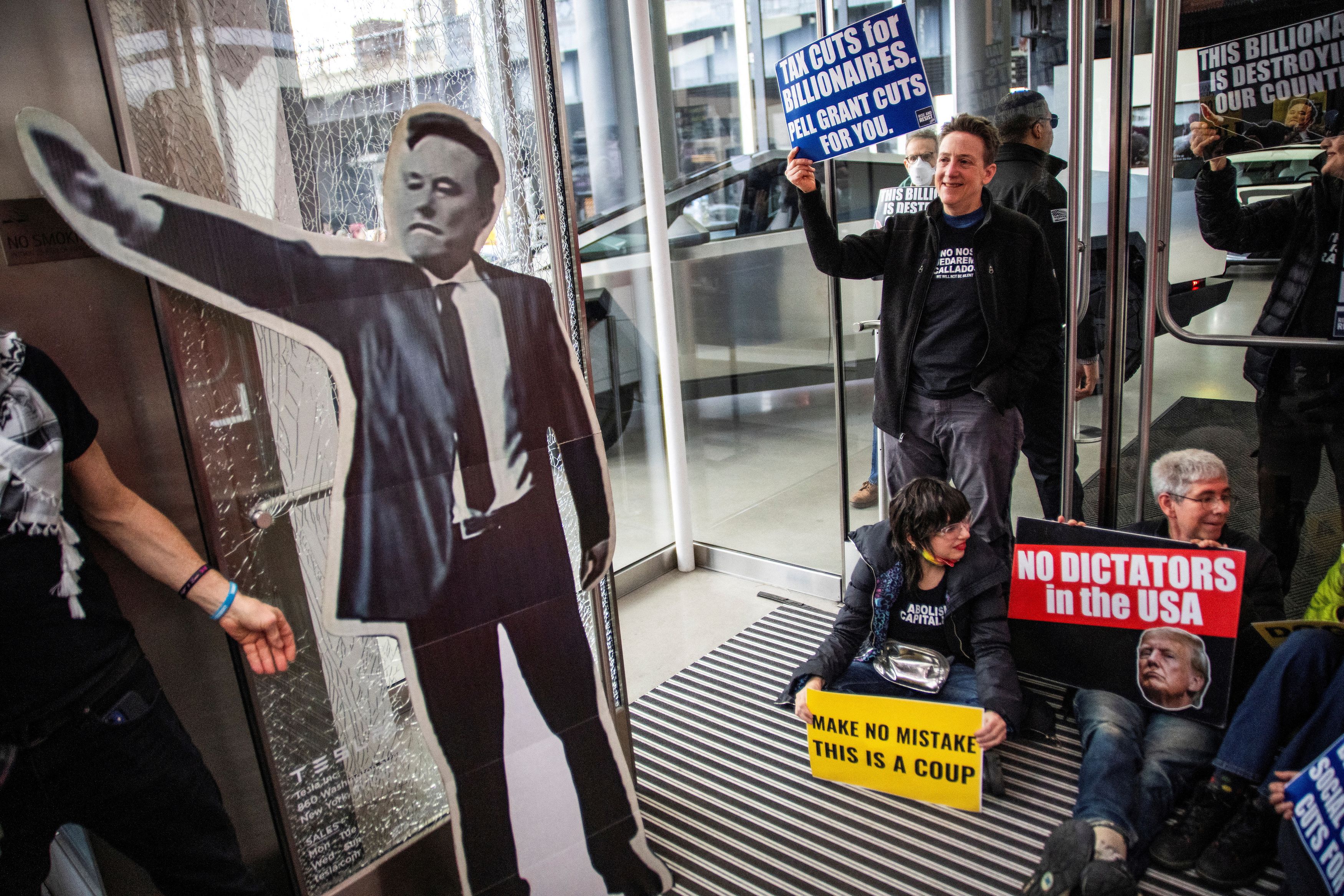 People protest inside a Tesla store during a National Day of Tesla Protest in New York City.