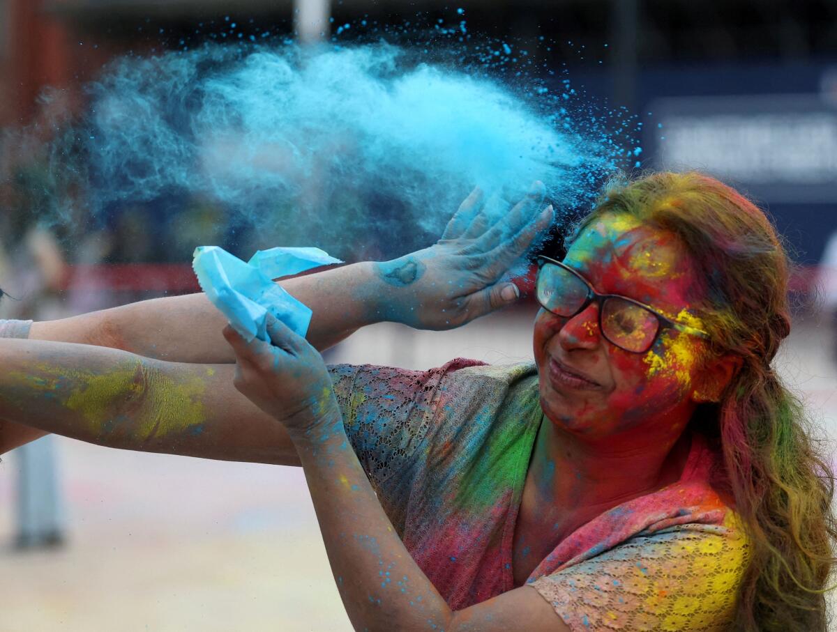 A student is covered in coloured powder during Holi festivities at Liverpool University in Liverpool, Britain, March 16, 2025.