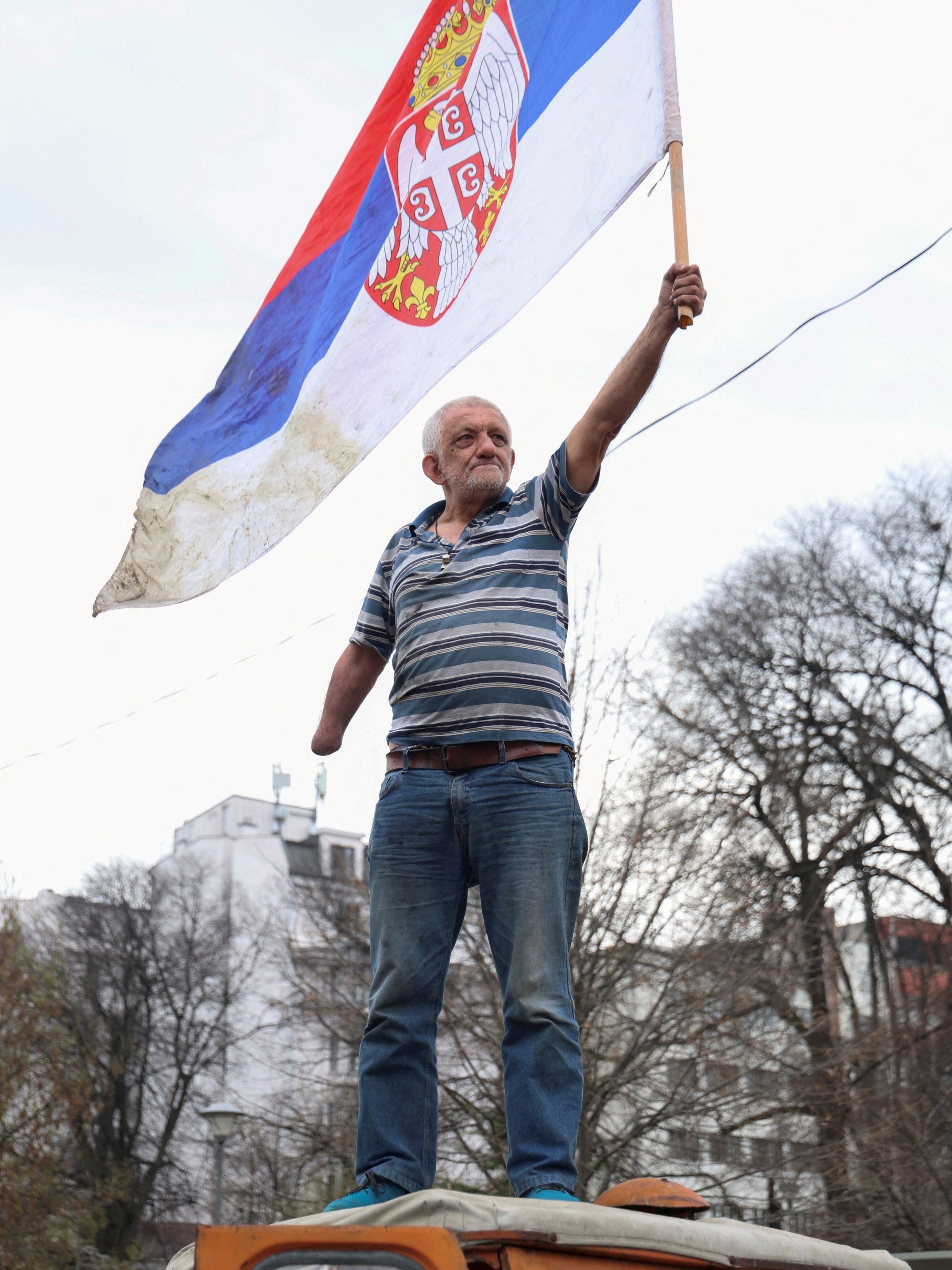 An anti-government demonstrator waves a Serbian flag during a protest in Belgrade, Serbia.