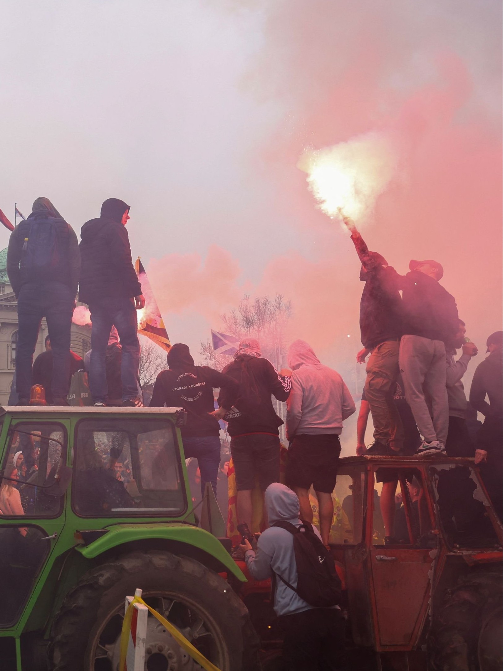 A man lights a flare as students and anti-government demonstrators take part in a protest in front of the parliament building in Belgrade, Serbia.