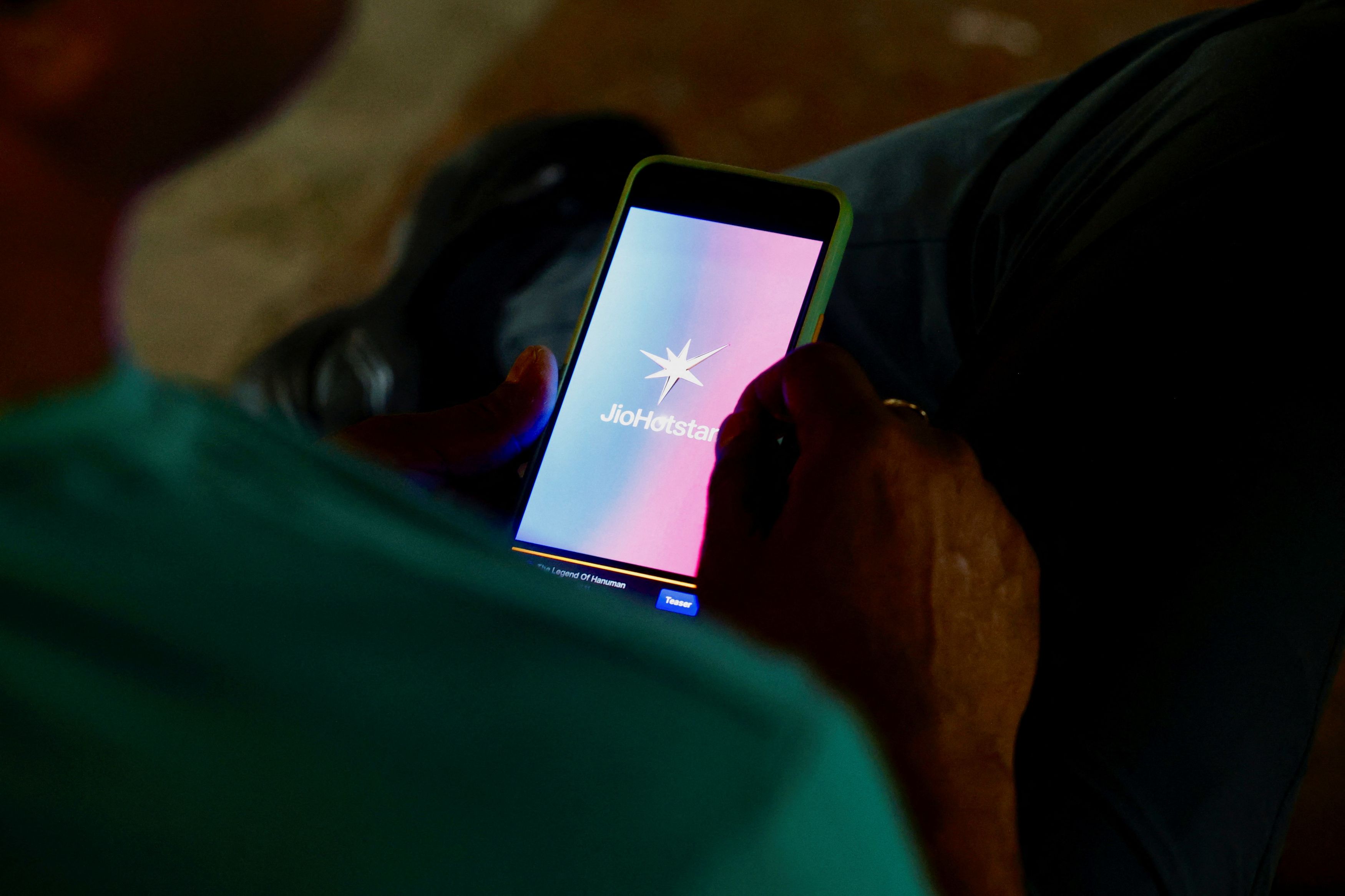 A man uses the JioHotstar app on his mobile phone in New Delhi, India.  