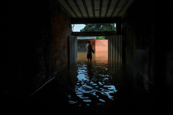 A man stands in flood water due to heavy rains as he looks at the sreet in Parque Mambucaba neighbourhood in Angra dos Reis, state of Rio de Janeiro, Brazil.