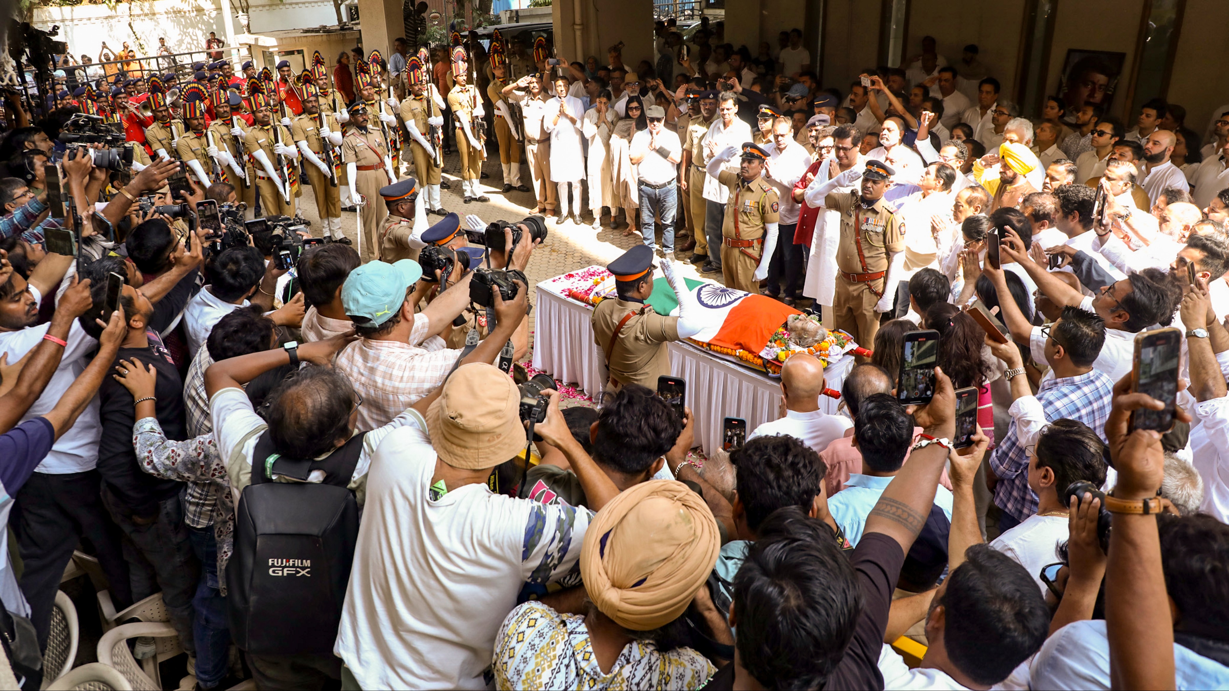 Police personnel pay tribute to veteran actor-filmmaker Manoj Kumar during his last rites.