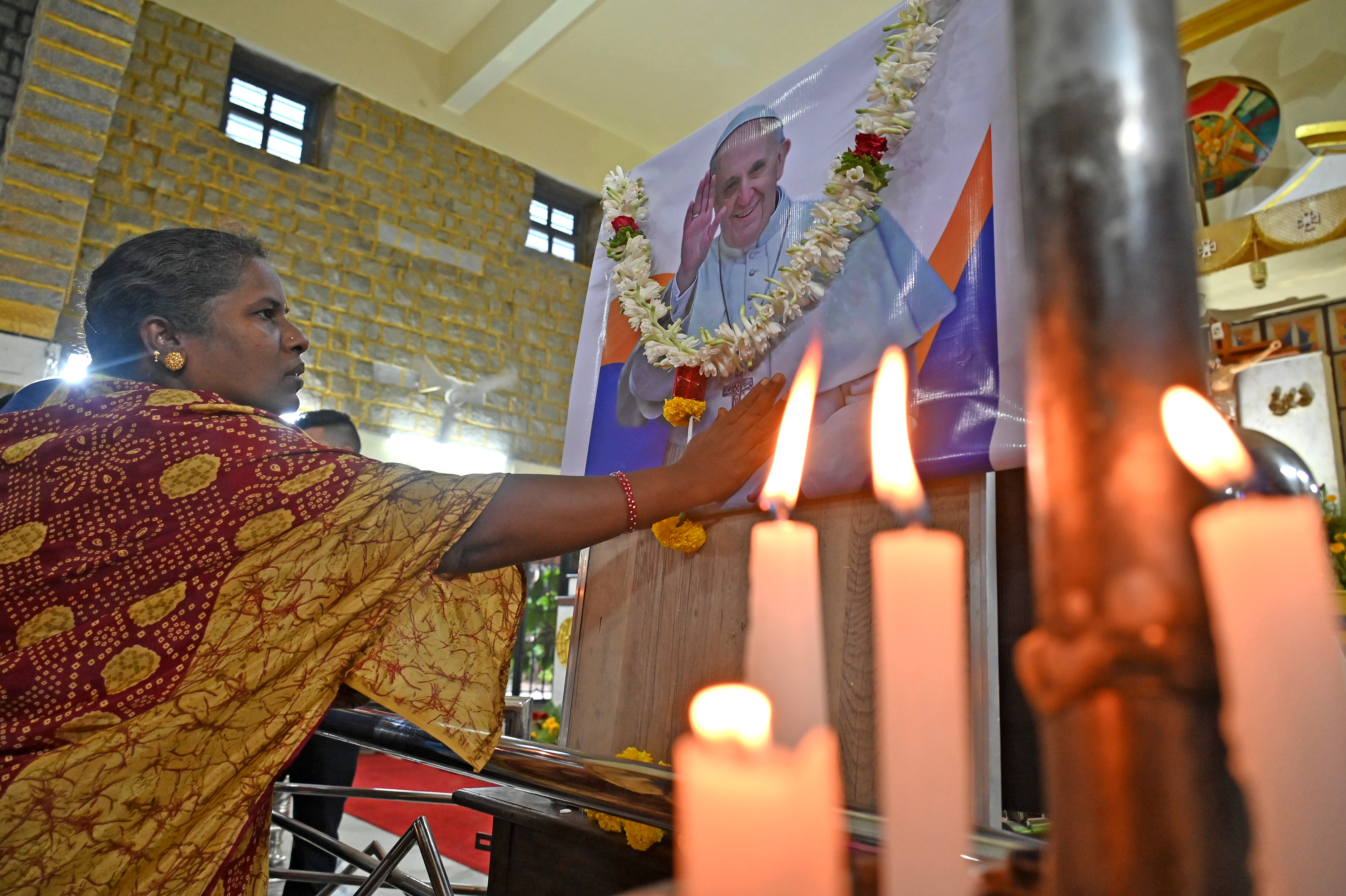 People light candles to pay tribute to Pope Francis at St Theresa