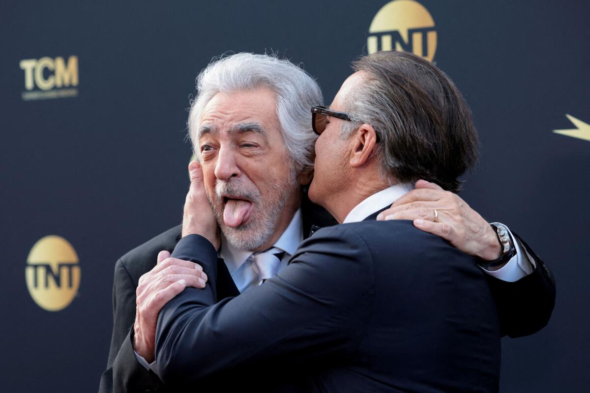 Joe Mantegna reacts as Andy Garcia embraces him as they attend the 50th AFI Life Achievement Award at Dolby Theatre in Los Angeles, California. 