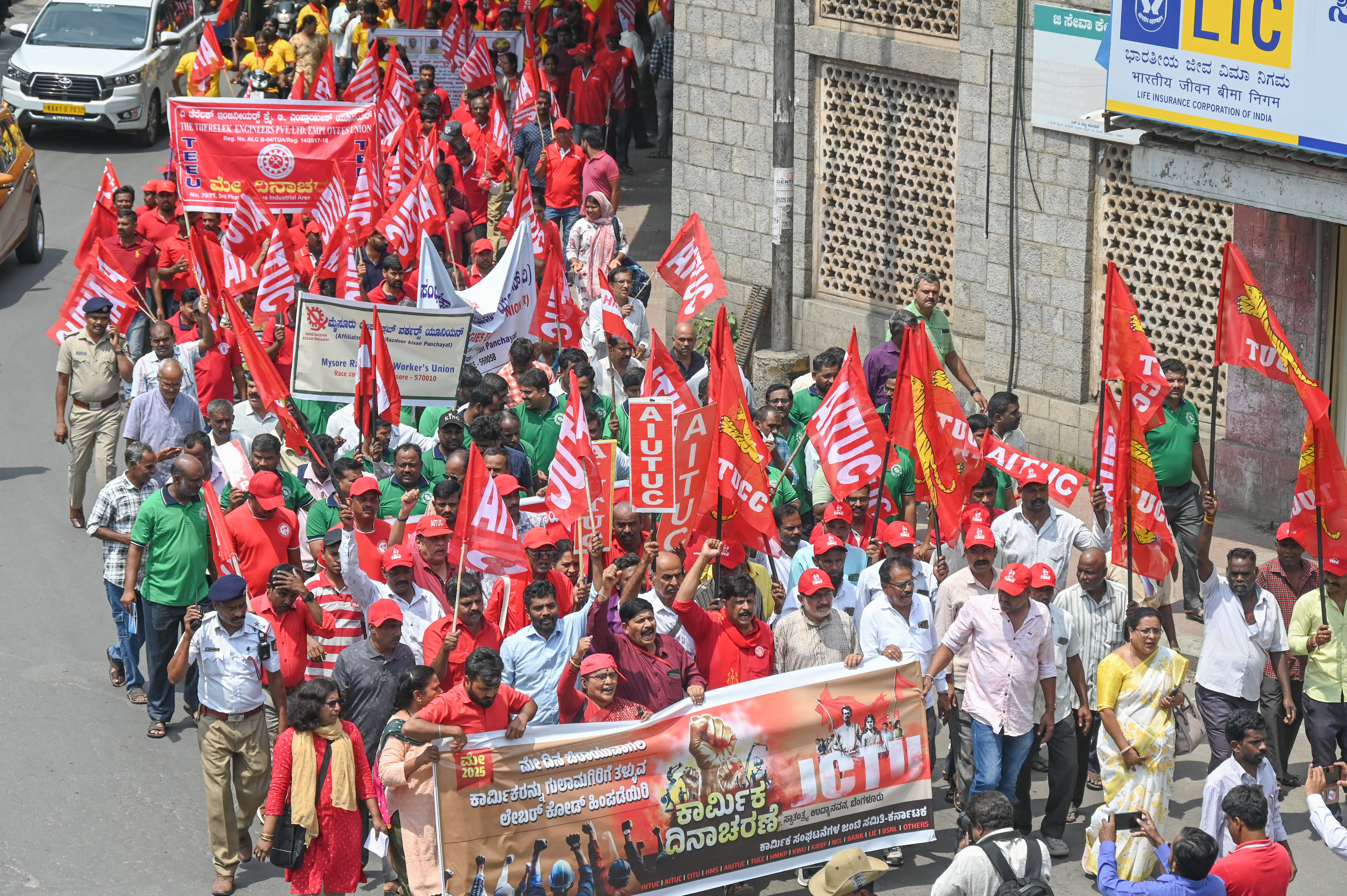 Members from various trade unions—AITUC INTUC HMS CITU AIUTUC AICCTU TUCC HMKP and the Joint Committee of Trade Unions (JCTU)—marched from Town Hall in Bengaluru on Thursday to mark International Workers’ Day. With banners held high they rallied for the abolition of contract employment enforcement of labour laws fair minimum wages and an end to 10-12 hour workdays demanding an 8-hour work shift for all. 