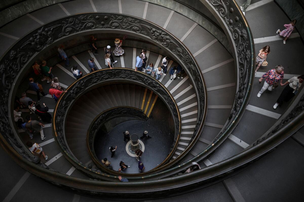 People descend the Bramante Staircase at the Vatican Museum during a press tour ahead of the conclave, at the Vatican, May 2, 2025.