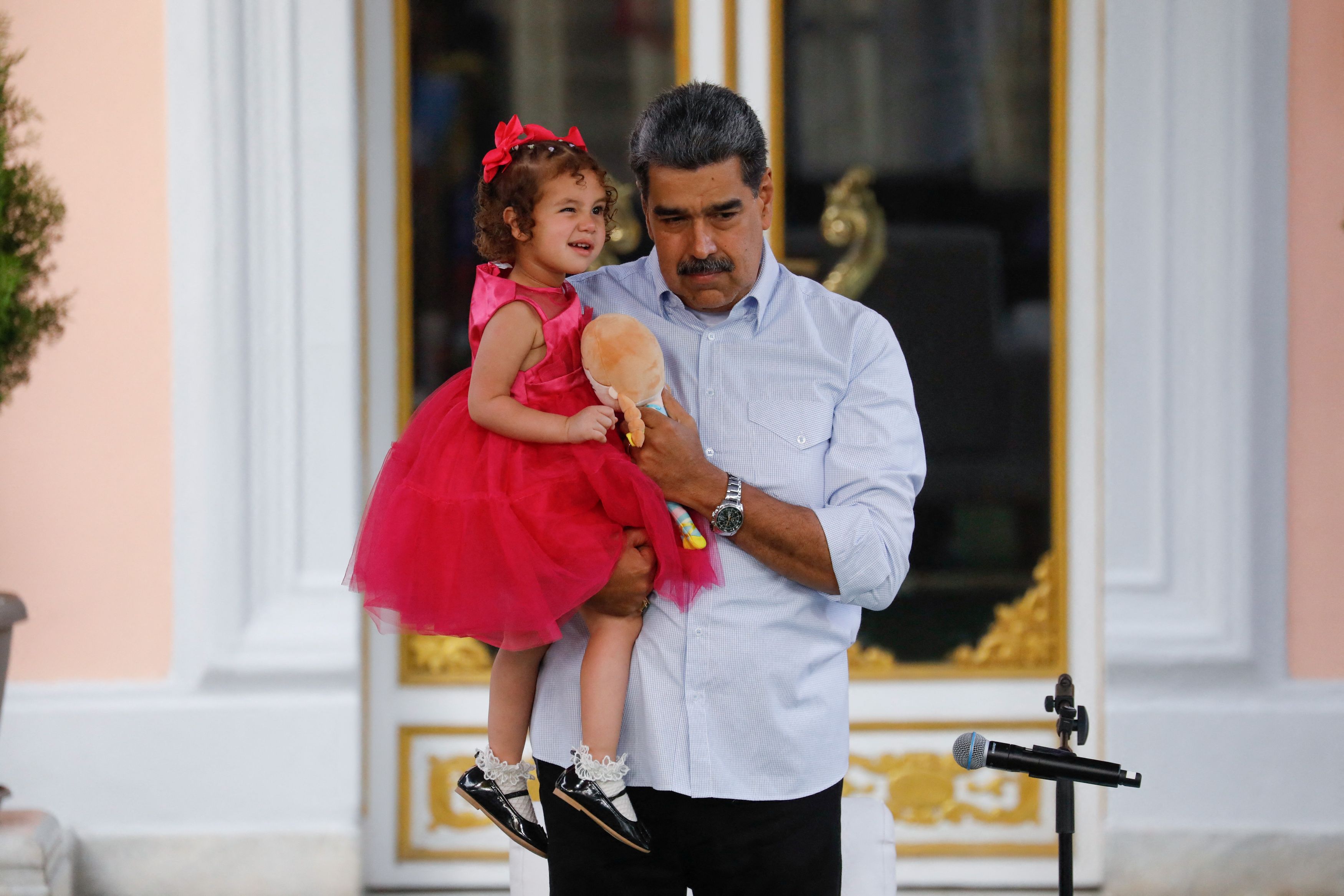 Venezuela's President Nicolas Maduro carries two-year-old Maikelys Espinoza Bernal, who remained in the U.S. following the deportation of her parents and was reunited with her mother yesterday, in Caracas, Venezuela