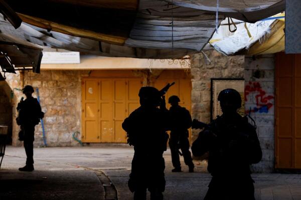 Israeli troops stand guard during a weekly settlers' tour in Hebron in the Israeli-occupied West Bank.