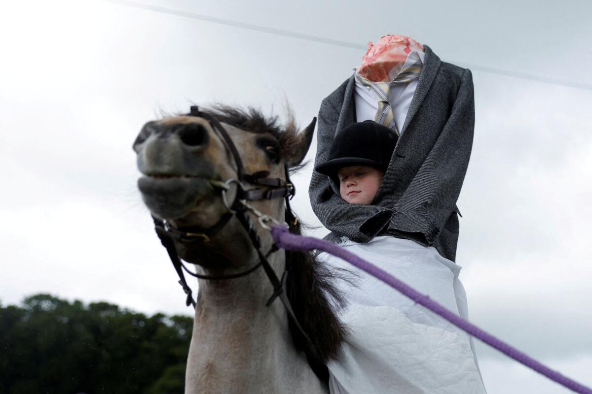 Sophie Hawkshaw (9), dressed as a Headless Horseman participates in a lead rein fancy dress competition for riders under 10 years old at an agricultural show, in Athenry, Ireland.
