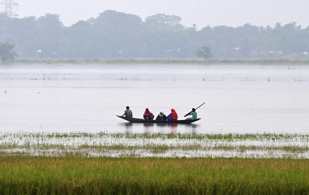 People use a boat to move to safer areas after heavy rainfall triggered floods in Nagaon district of Assam